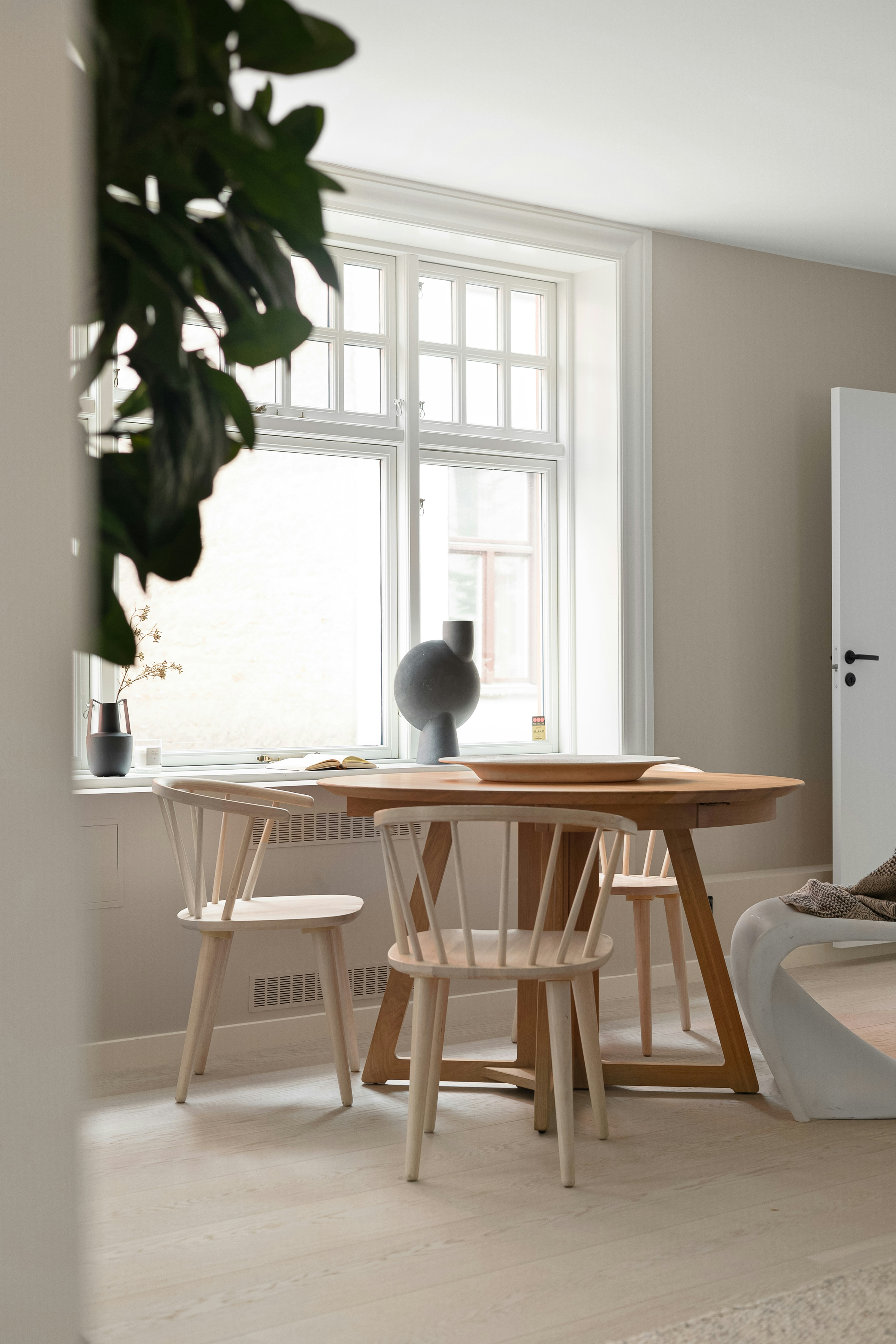 A room with a table and chairs and a potted plant